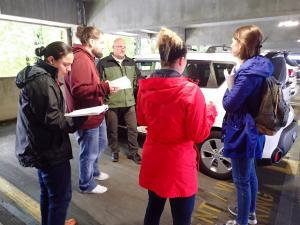 Image showing students gathered outside of a passenger vehicle receiving education from an Instructor