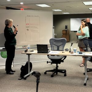 Instructional designer Rebecca Adler works at the whiteboard during a Board meeting in Itasca.