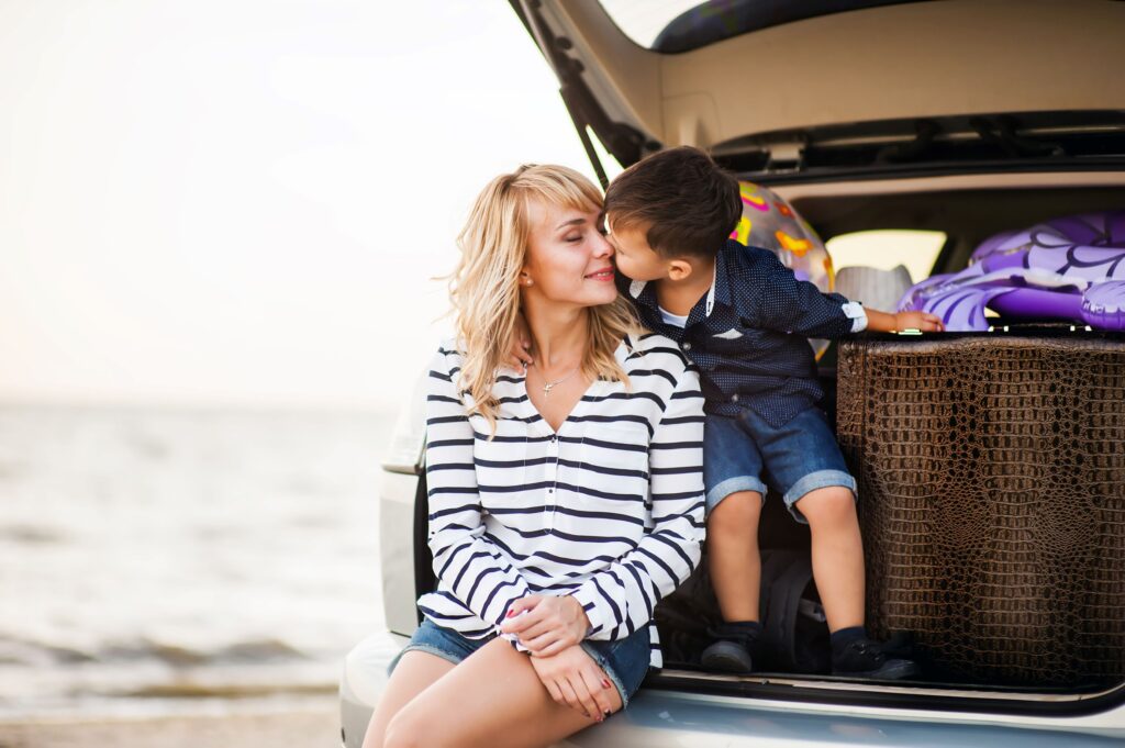 A little boy snuggles with his mother as the two take a break on a summer road trip.