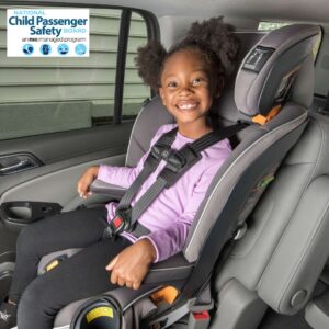 A little girl flashes her beaming smile while sitting in her forward-facing car seat.